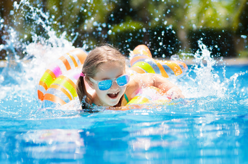 Girl Swimming in the pool with colorful floatie